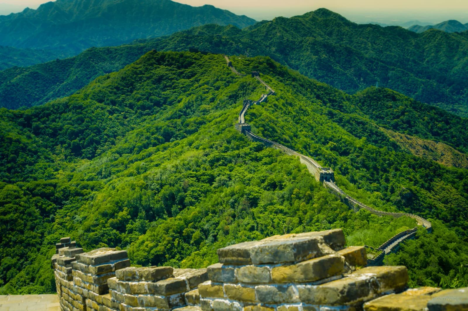 Watchtowers and stone battlements above green hills at Mutianyu