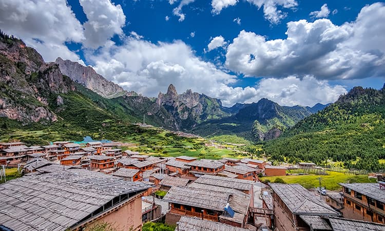 Village rooftops and dramatic mountain peaks in Zhagana